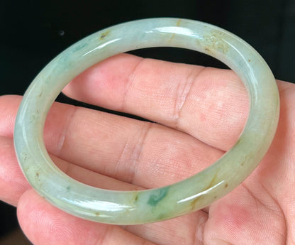 Close-up of honey and imperial green marbling on icy apple green jadeite bangle
