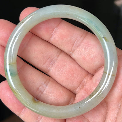 Close-up of honey and imperial green marbling on icy apple green jadeite bangle