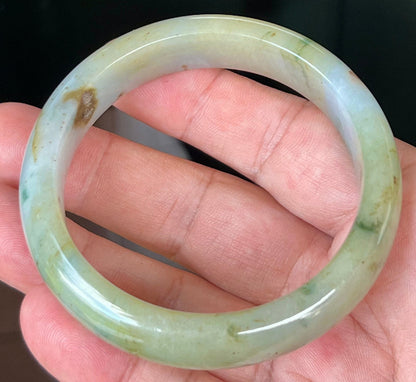 Close-up of imperial green and honey hues on icy apple jadeite bangle