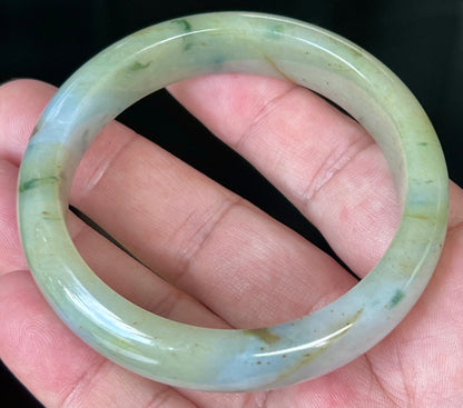 Close-up of imperial green and honey hues on icy apple jadeite bangle
