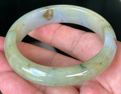 Close-up of imperial green and honey hues on icy apple jadeite bangle