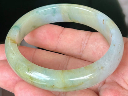 Close-up of imperial green and honey hues on icy apple jadeite bangle
