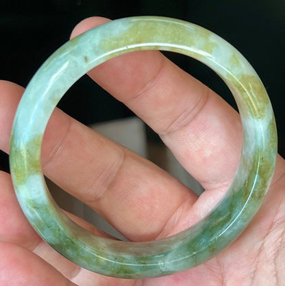 Close-up of moss green and milky white hues on icy apple green jadeite bangle