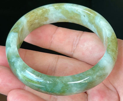 Close-up of moss green and milky white hues on icy apple green jadeite bangle