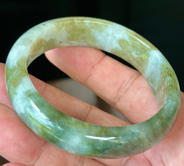 Close-up of moss green and milky white hues on icy apple green jadeite bangle