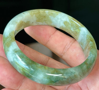 Close-up of moss green and milky white hues on icy apple green jadeite bangle