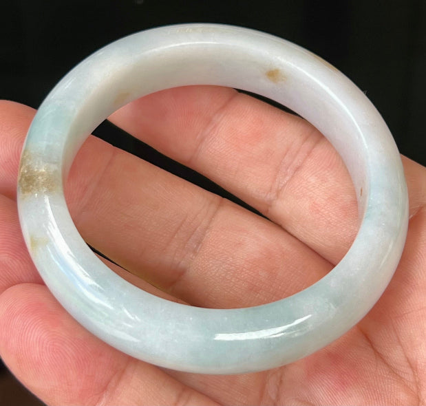 Close-up of honey brown hues on icy bluish milky white jadeite bangle