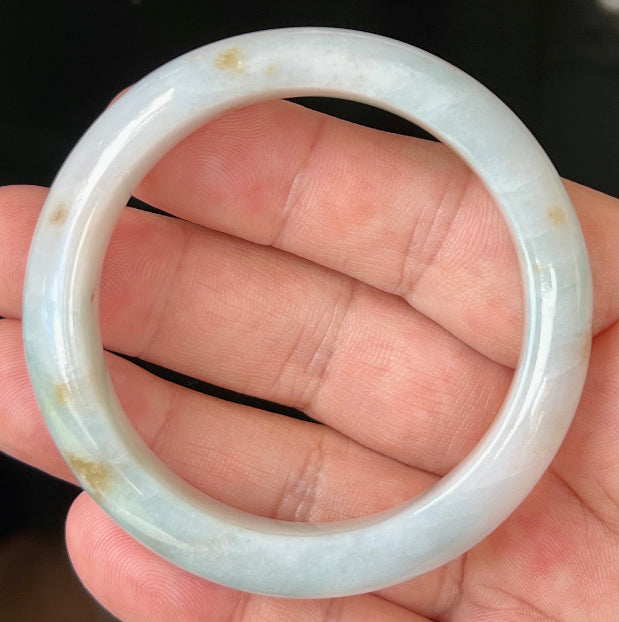 Close-up of honey brown hues on icy bluish milky white jadeite bangle