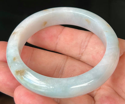 Close-up of honey brown hues on icy bluish milky white jadeite bangle