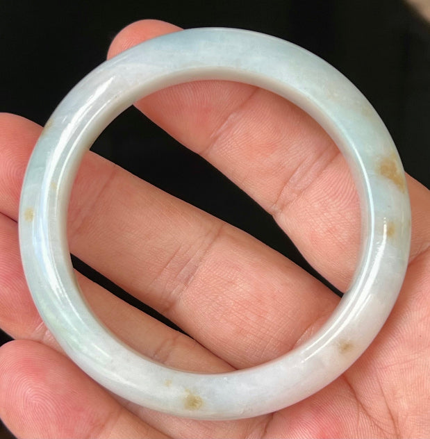 Close-up of honey brown hues on icy bluish milky white jadeite bangle