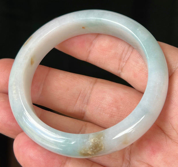 Close-up of honey brown hues on icy bluish milky white jadeite bangle