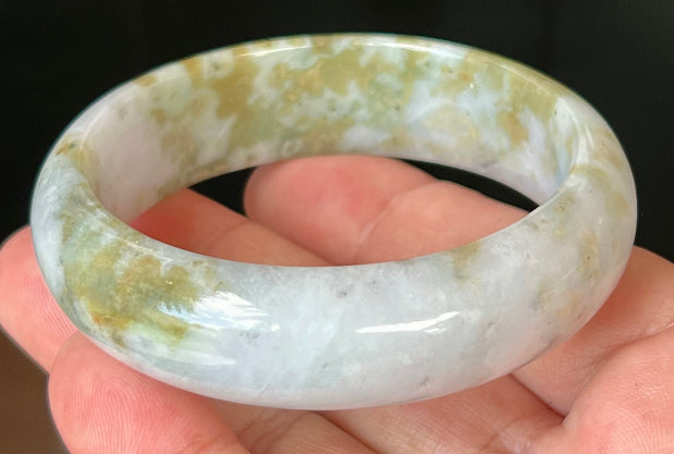 Close-up of apple moss green accents on icy grey jadeite bangle