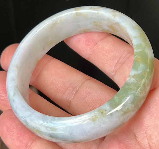 Close-up of apple moss green accents on icy grey jadeite bangle