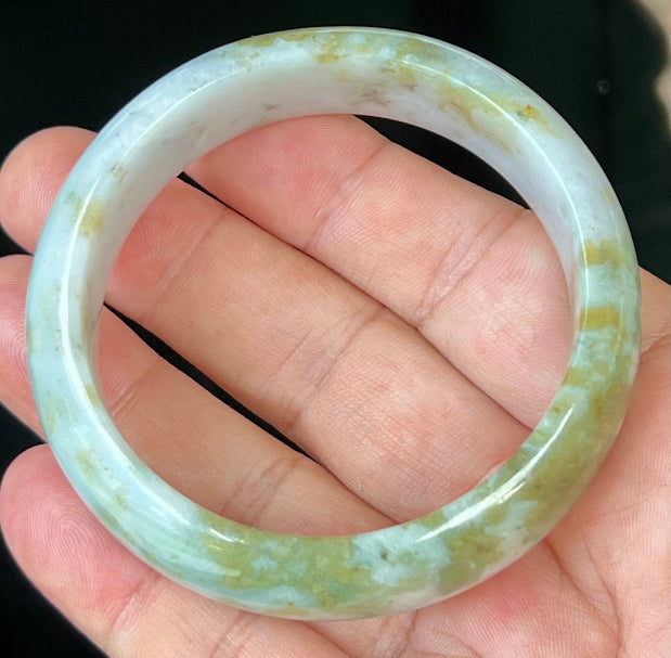 Close-up of apple moss green accents on icy grey jadeite bangle
