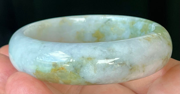 Close-up of apple moss green accents on icy grey jadeite bangle