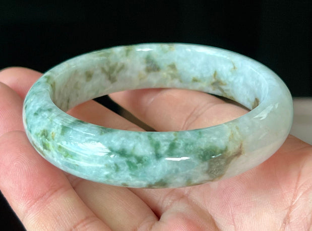 Close-up of imperial green and honey hues on icy milky white jadeite bangle