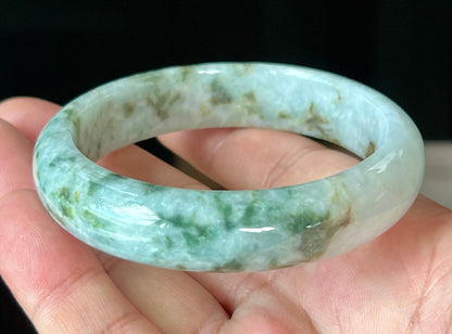 Close-up of imperial green and honey hues on icy milky white jadeite bangle