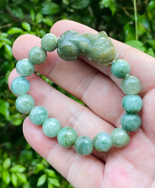 Close-up of a 10mm natural Grade A certified Burmese jadeite beaded bracelet featuring mossy green beads and a Pixiu pendant, item JBB164