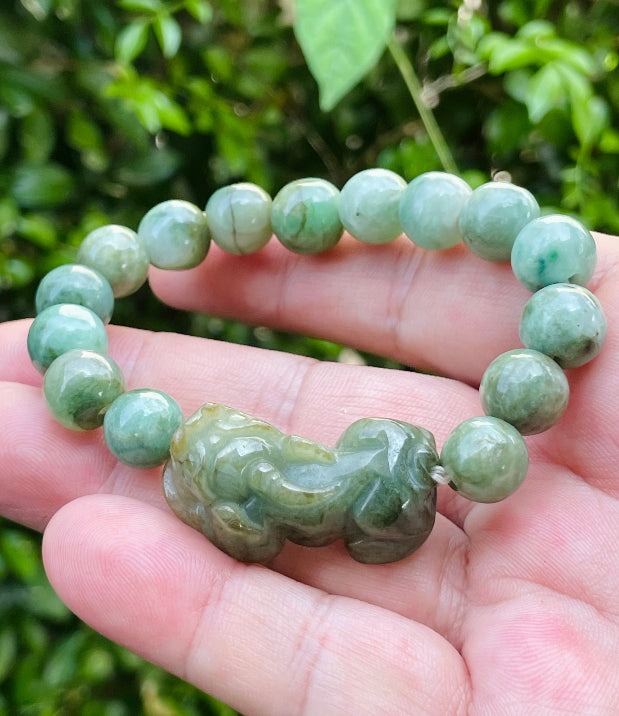 Handcrafted genuine Grade A Burmese jadeite stretch bracelet showcasing beautiful mossy green beads with a hand-carved Pixiu pendant and official certification