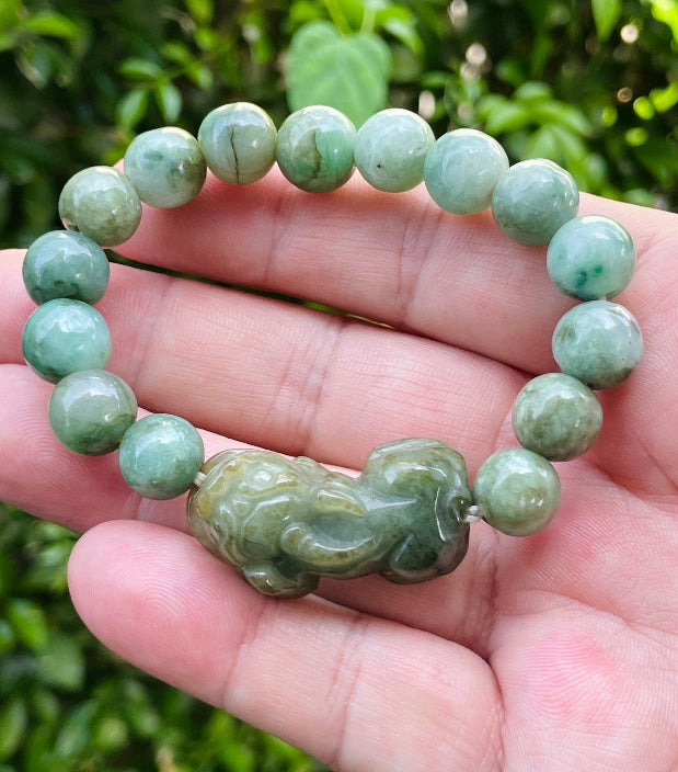 Handcrafted genuine Grade A Burmese jadeite stretch bracelet showcasing beautiful mossy green beads with a hand-carved Pixiu pendant and official certification