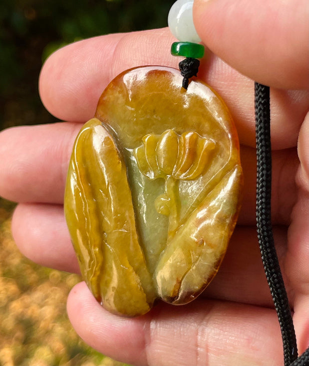 Handcrafted genuine Grade A certified Burmese jadeite amulet with orange and olive green colors representing warmth and prosperity