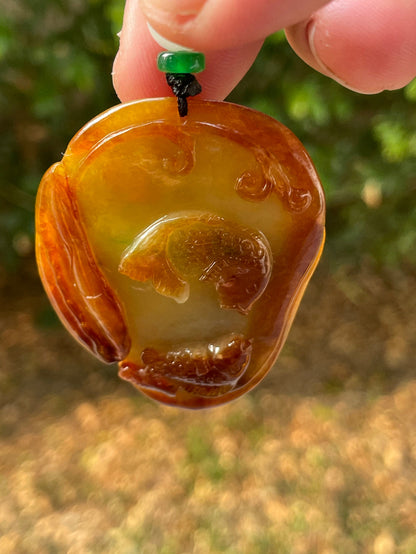 Handcrafted genuine Grade A certified Burmese jadeite amulet with orange and olive green colors representing warmth and prosperity
