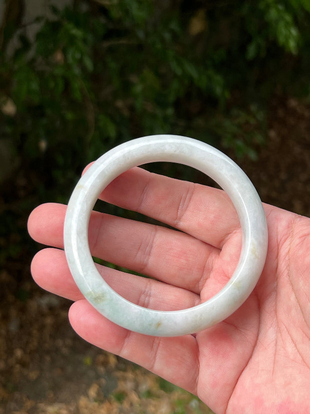 Close-up of pale celadon green highlights on icy milky white jadeite bangle