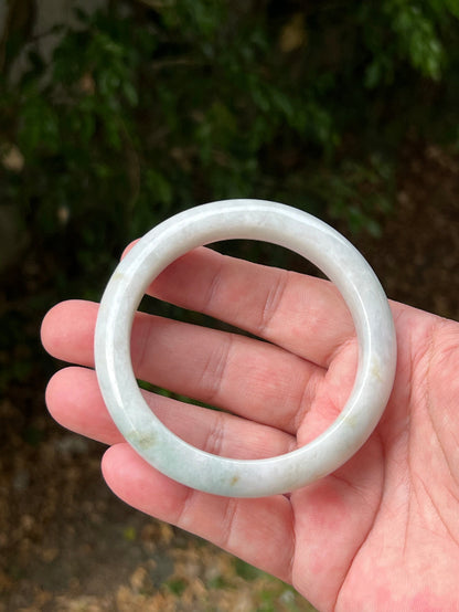 Close-up of pale celadon green highlights on icy milky white jadeite bangle