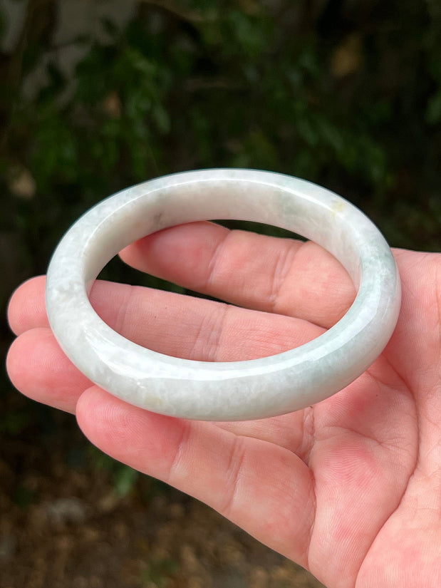 Close-up of pale celadon green highlights on icy milky white jadeite bangle