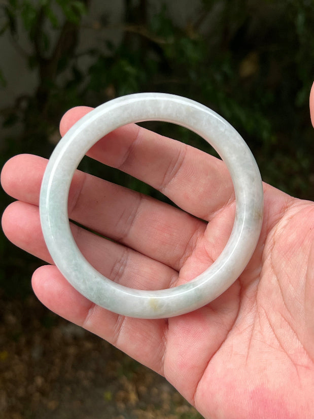 Close-up of pale celadon green highlights on icy milky white jadeite bangle