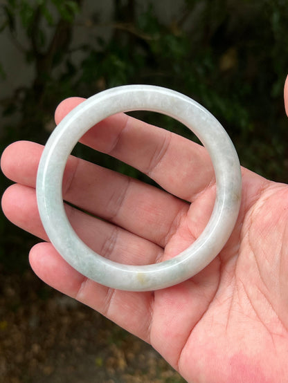 Close-up of pale celadon green highlights on icy milky white jadeite bangle
