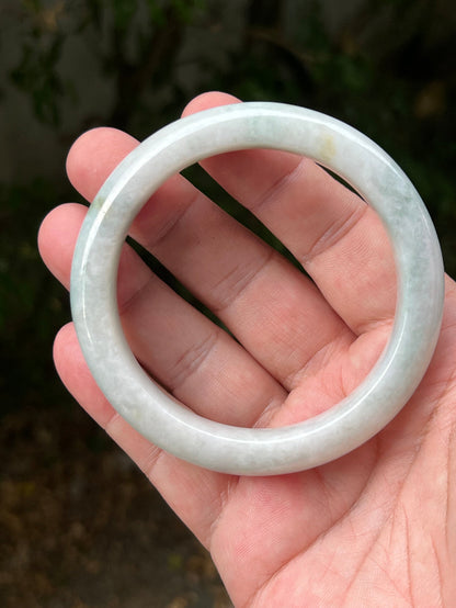 Close-up of pale celadon green highlights on icy milky white jadeite bangle