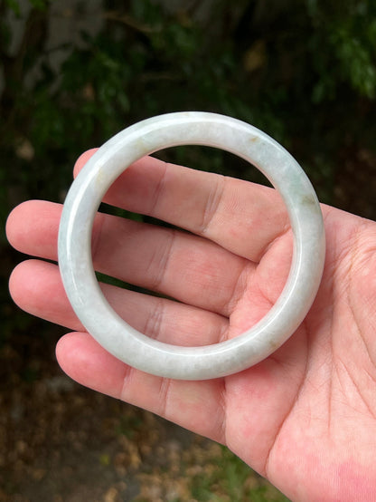 Close-up of pale celadon green highlights on icy milky white jadeite bangle