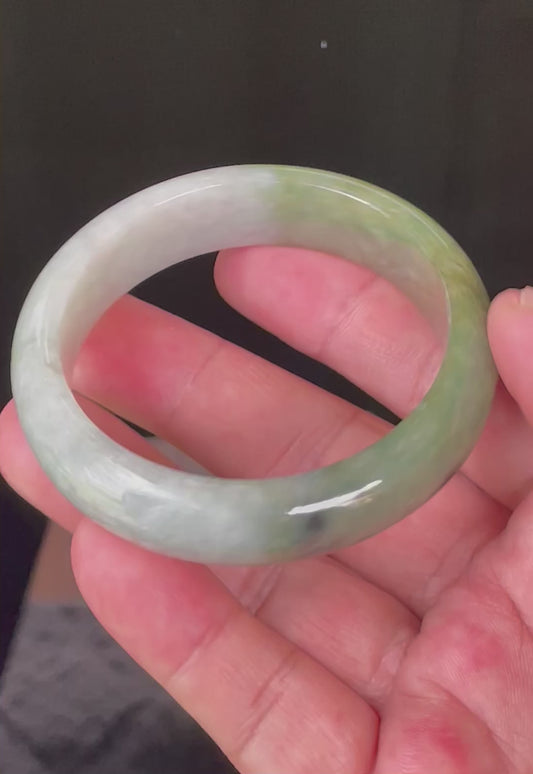 Video showcasing the bright glassy luster and fine crystalline texture of icy apple green, greyish milky white, and black Burmese jadeite bangle JB050