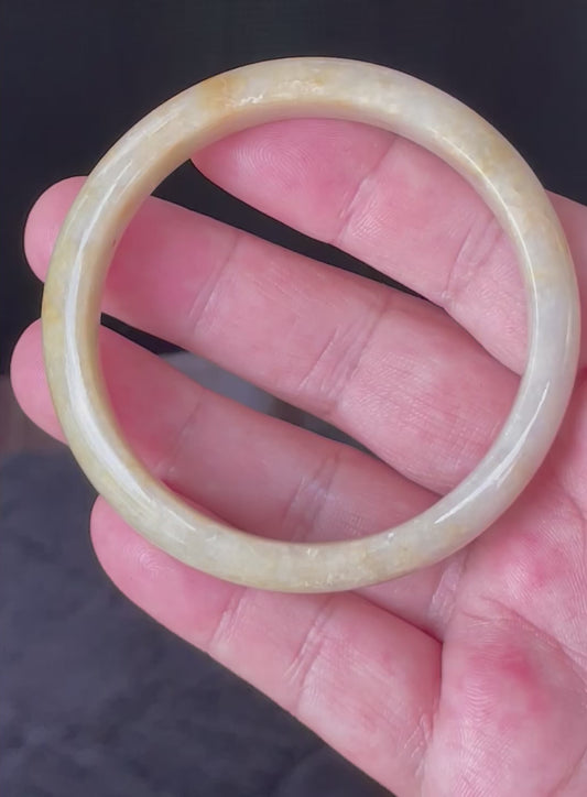 Video showcasing the vitreous luster and fine crystalline texture of icy yellow and honey orange Burmese jadeite bangle JB923