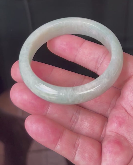 Video showcasing the natural glassy luster and fine crystalline texture of icy apple green and milky white Burmese jadeite bangle JB518