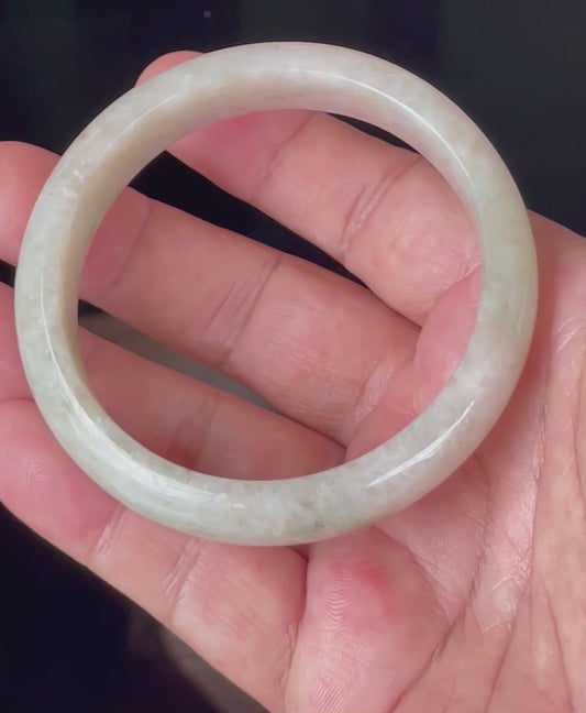Video showcasing the natural glassy luster and fine crystalline texture of icy honey, milky white and light imperial green Burmese jadeite bangle JB352
