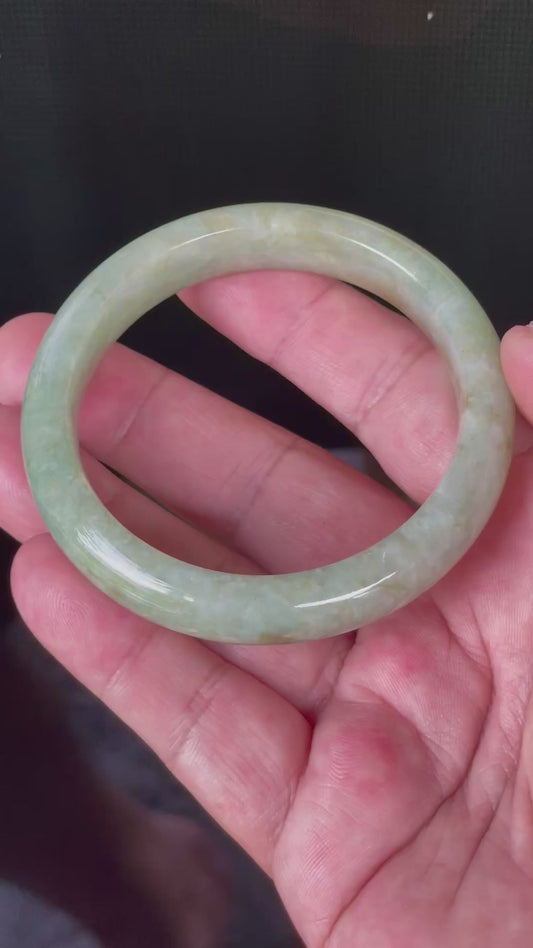 Video showcasing the vitreous luster and fine crystalline texture of icy apple green, milky white, and honey brown Burmese jadeite bangle JB830