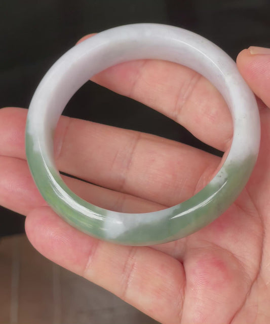 Video showcasing the natural glassy luster and fine crystalline texture of icy greyish milky white, apple and imperial green Burmese jadeite bangle JB096