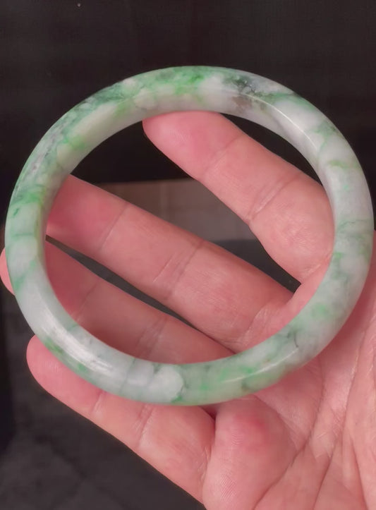 Video showcasing the vitreous luster and floral moss in the snow pattern of icy imperial green and apple green Burmese jadeite bangle JB933