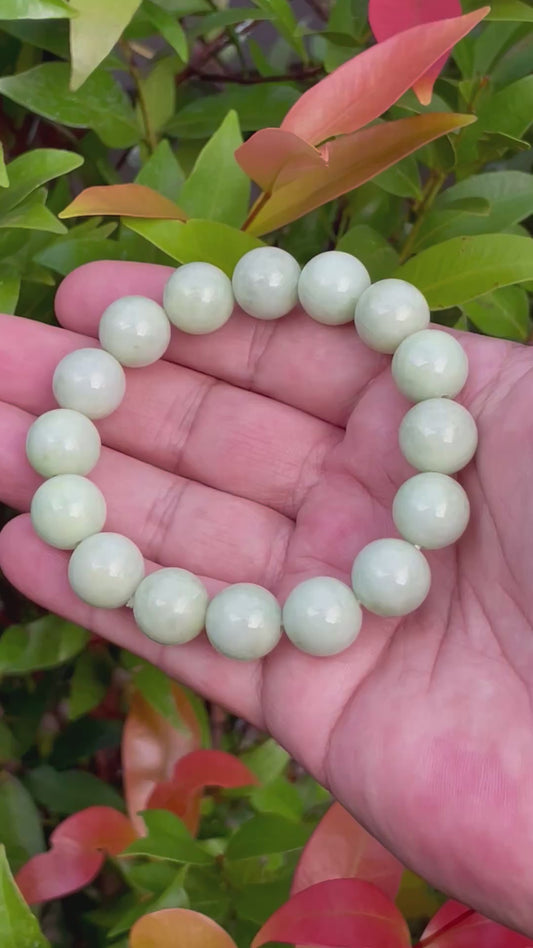 Video showcasing the vitreous luster and harmonious blend of icy apple green, forest green, and milky white hues of the 13.4mm Burmese jade bead bracelet JBB171