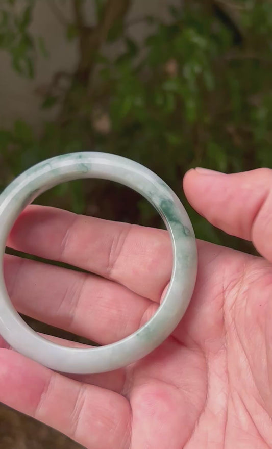 Video showcasing the natural luster and moss in snow patterns of icy green and milky white Burmese jadeite bangle JB1293
