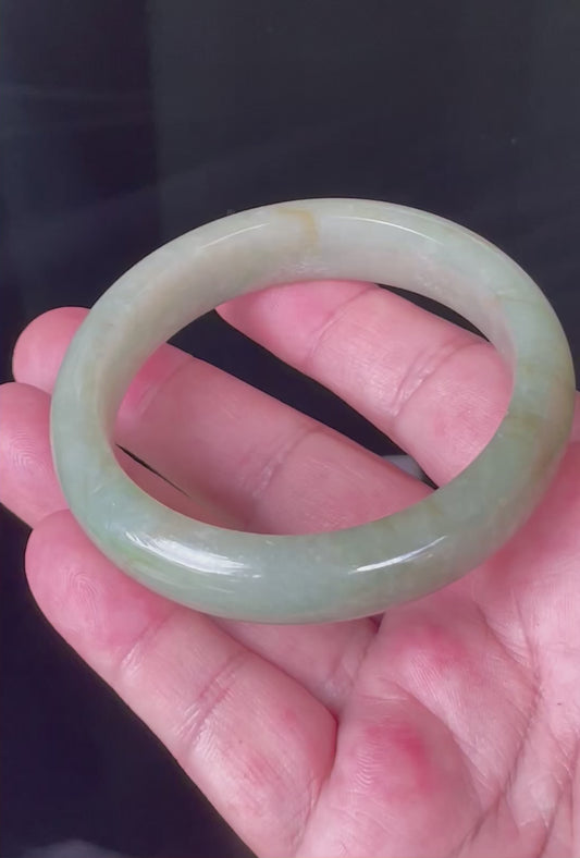 Video showcasing the natural glassy luster and fine crystalline texture of icy apple green, milky white, and honey Burmese jadeite bangle JB212