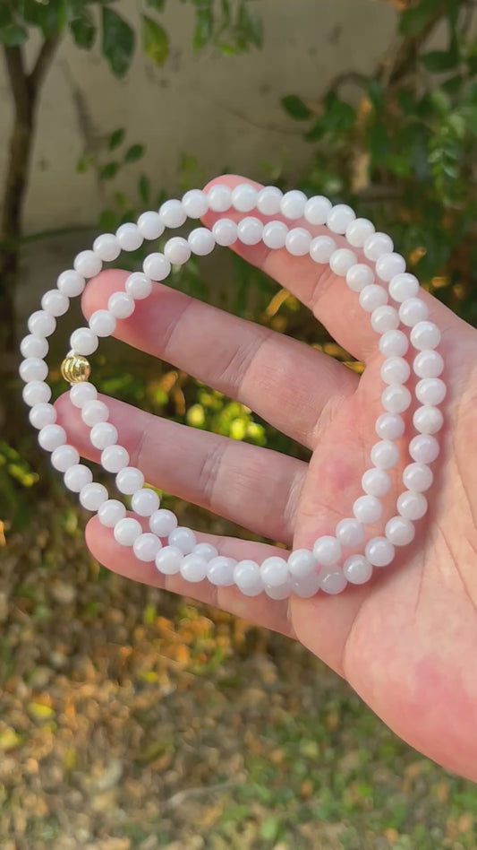 Video showcasing the soft glassy luster and elegant icy milky white and light lavender color palette of the 7mm certified Burmese jade bead necklace JN091