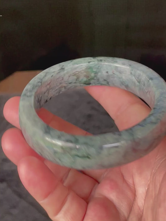 Video showcasing the vitreous luster and fine crystalline texture of icy black, greyish, apple green, and moss green Burmese jadeite flat bangle JB935