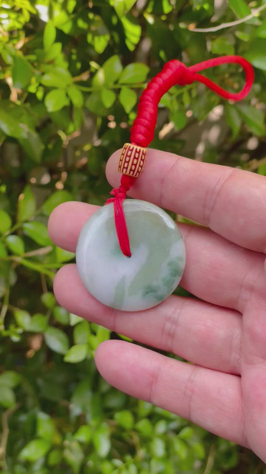 Video showcasing the semi-gloss luster, forest green and milky white hues, and classic round disc shape of the Burmese jade pendant JP061