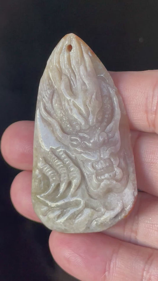 Video showcasing the vitreous translucency, icy light greyish brown and honey-orange hues, and hand-carved double-sided dragon and fish motif of the certified Burmese jade pendant JP070