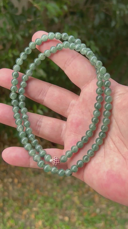Video showcasing the soft glassy luster and elegant icy imperial and deep emerald green color palette of the 6.4mm certified Burmese jade bead necklace JN092