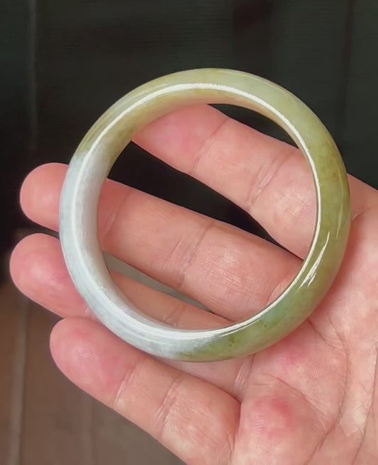 Video showcasing the natural glassy luster and fine crystalline texture of icy apple green and honey Burmese jadeite bangle JB521