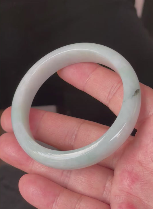 Video showcasing the bright glassy luster and fine crystalline texture of icy greyish milky white, light apple green, and bluish Burmese jadeite bangle JB231